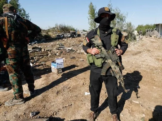 kataib hezbollah fighters are seen at the site of an american strike in hillah iraq in december 2023 photo reuters kataib hezbollah fighters are seen at the site of an american strike in hillah iraq in december 2023 photo reuters